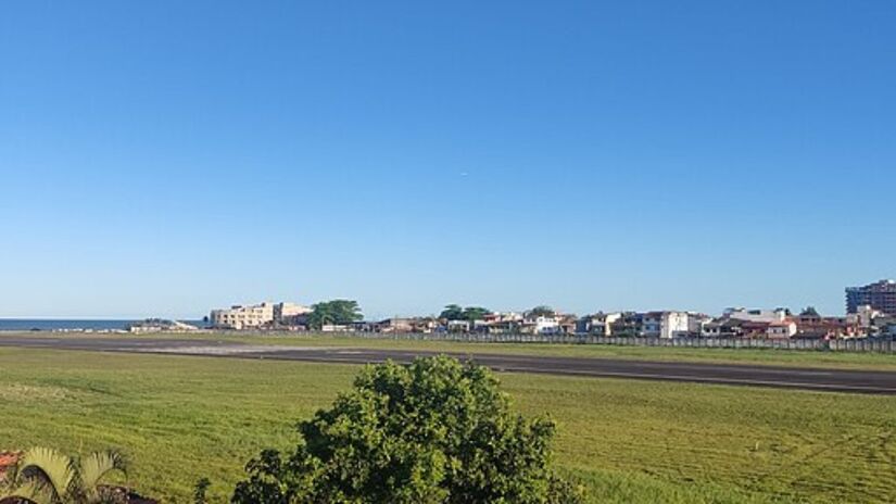 Localizado em uma das regiões mais turísticas da Bahia, o Aeroporto Jorge Amado, em Ilhéus, é um dos aeroportos mais desafiadores do Brasil. O que torna o aeroporto peculiar e arriscado é sua proximidade com o mar e a geografia que cerca a cidade. 

O Aeroporto Jorge Amado possui uma pista localizada bem próxima à orla, o que oferece aos passageiros uma vista incrível do oceano, mas ao mesmo tempo desafia os pilotos. 

Ventos fortes vindos do mar podem desestabilizar as aeronaves durante as manobras de pouso e decolagem. Outro ponto que agrava a complexidade deste aeroporto é o clima da região, que frequentemente alterna entre sol intenso e chuvas repentinas. 

Em dias nublados, a visibilidade reduzida se torna um fator de risco adicional, dificultando a precisão nas manobras de aterrissagem. 

Além disso, a pista relativamente curta em comparação a outros grandes aeroportos impõe restrições às aeronaves maiores, aumentando ainda mais o desafio para os pilotos, que precisam ser extremamente precisos em suas abordagens.

Fotos: Wikimedia Commons