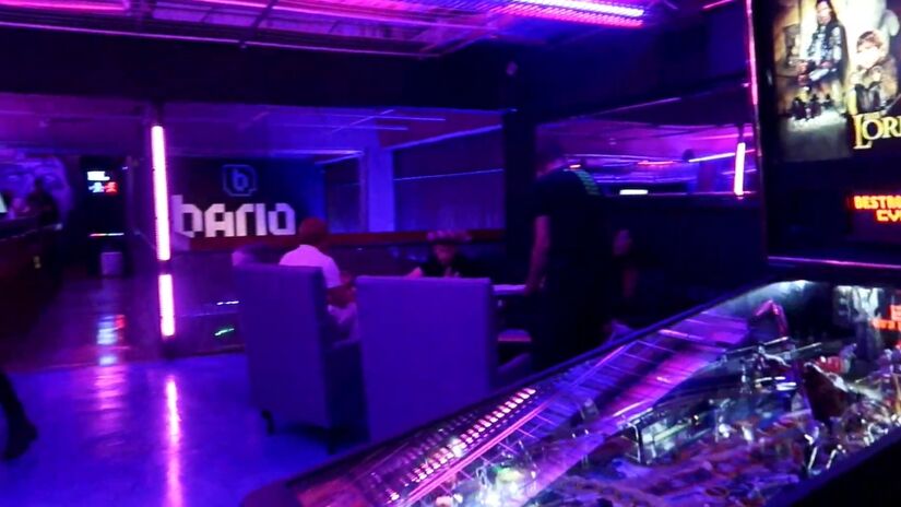 Além dos jogos, o Bario Bar conta com um menu diversificado que inclui porções, lanches e o famoso Bario Burger. Há opções para todos os gostos, desde aperitivos veganos até sanduíches clássicos, como o Pac Man Burger, de linguiça toscana e cebola caramelizada.