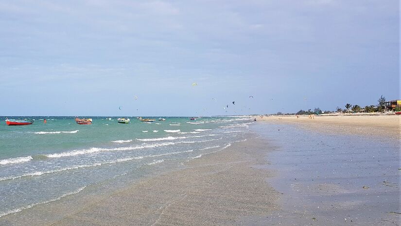 Os paraquedas de kitesurfing convivem quiosques na Praia do Preá. Fabiobarros/Wikimedia Commons