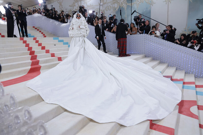 Rihanna durante o MET Gala 2023; estrela usou um longo vestido branco da Valentino com cauda de cinco metros de comprimento e um casaco de 30 camélias (um dos códigos da Chanel) feitas de 500 pétalas. Foto: Agência Efe/Folhapress