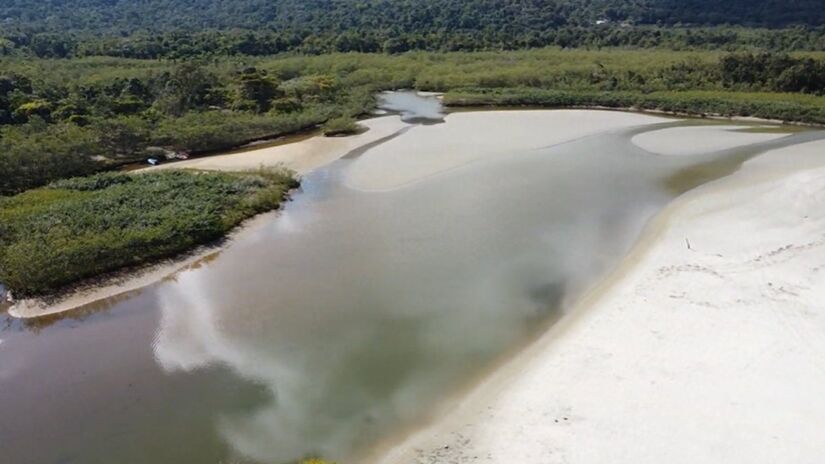 A foz do Rio Ubatumirim deságua no local, dividindo-o da Praia do Estaleiro do Padre (Foto: Reprodução YouTube/Turistando por aí com o Guia)