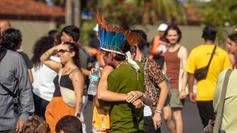 Estrangeira abraça indígena em frente ao edifício da COP30/Toninho Castro/Agência Brasil