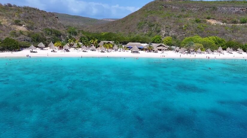 Agora em destaque devido ao seu sucesso no mundo do futebol, Curaçao é considerado um paraíso caribenho, com praias de águas cristalinas, arquitetura colorida em Willemstad, e um clima agradável fora da rota de furacões - (Reprodução/YouTube)