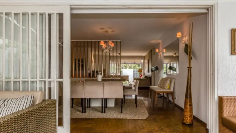 Sala de estar e de televisão da casa possui porta de correr que abre para o jardim.