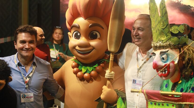 O grupo Bicharada do Juaba, da cidade paraense de Cametá, posa ao lado do mascote da COP30 e do ministro do Turismo, Celso Sabino/Toninho Castro/Agência
