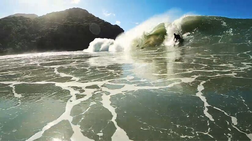A faixa de areia firme é ideal para caminhadas tranquilas, enquanto o mar muda de cor ao longo do dia, entre tons de azul e verde intenso