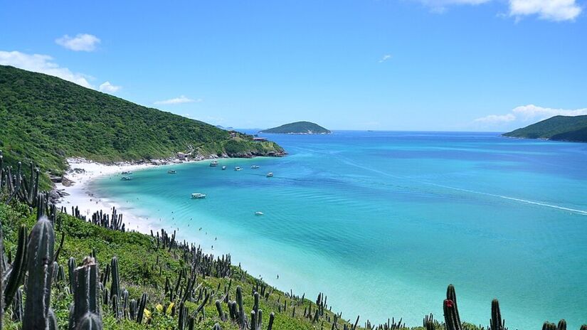 Em Arraial do Cabo, na Região dos Lagos, o contraste da água azul intensa com a areia branca e as encostas de pedra ajuda a explicar por que o destino é chamado de Caribe brasileiro do Sudeste, com passeios de barco que cabem em diferentes orçamentos.