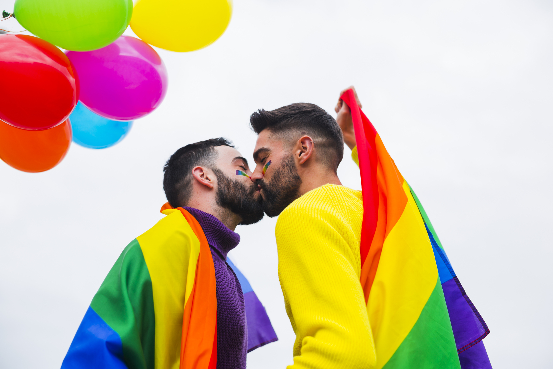 Jovem casal gay beijando na parada