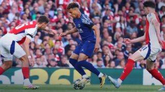 Desire Doué, jogador do PSG, cercado por dois jogadores do Arsenal