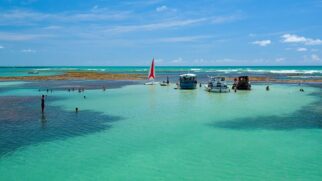 Piscinas naturais aparecem na maré baixa e revelam águas cristalinas com peixes e corais no litoral da Paraíba (Foto: MTur Destinos/Wikimedia Commons)