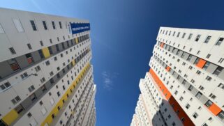 Prédios em São Paulo observados de baixo para cima. Há uma faixa do programa habitacional Pode Entrar da prefeitura