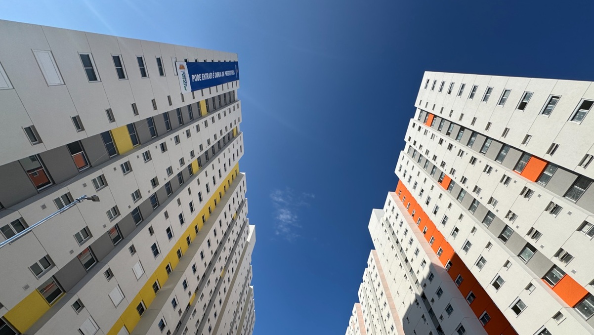Prédios em São Paulo observados de baixo para cima. Há uma faixa do programa habitacional Pode Entrar da prefeitura