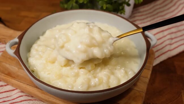 Uma colher com canjica cremosa