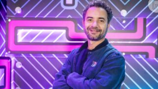 Marco Luque, humorista da TV Globo, posado de braços cruzados