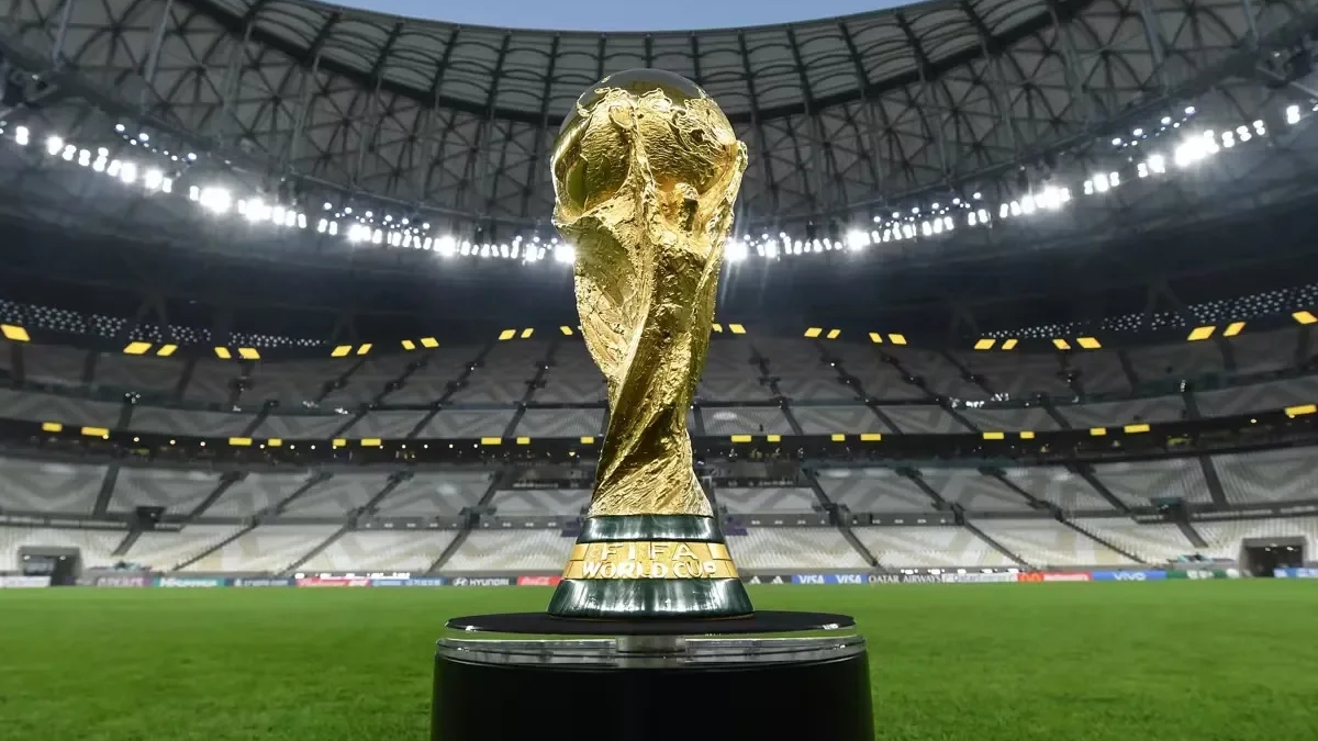 Troféu da Copa do Mundo posada com as arquibancadas de um estádio de fundo
