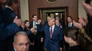 Donald Trump no centro, com pessoas ao redor.