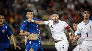 Jogador da seleção do Uruguai disputa bola com jogado do Uzbequistão em amistoso