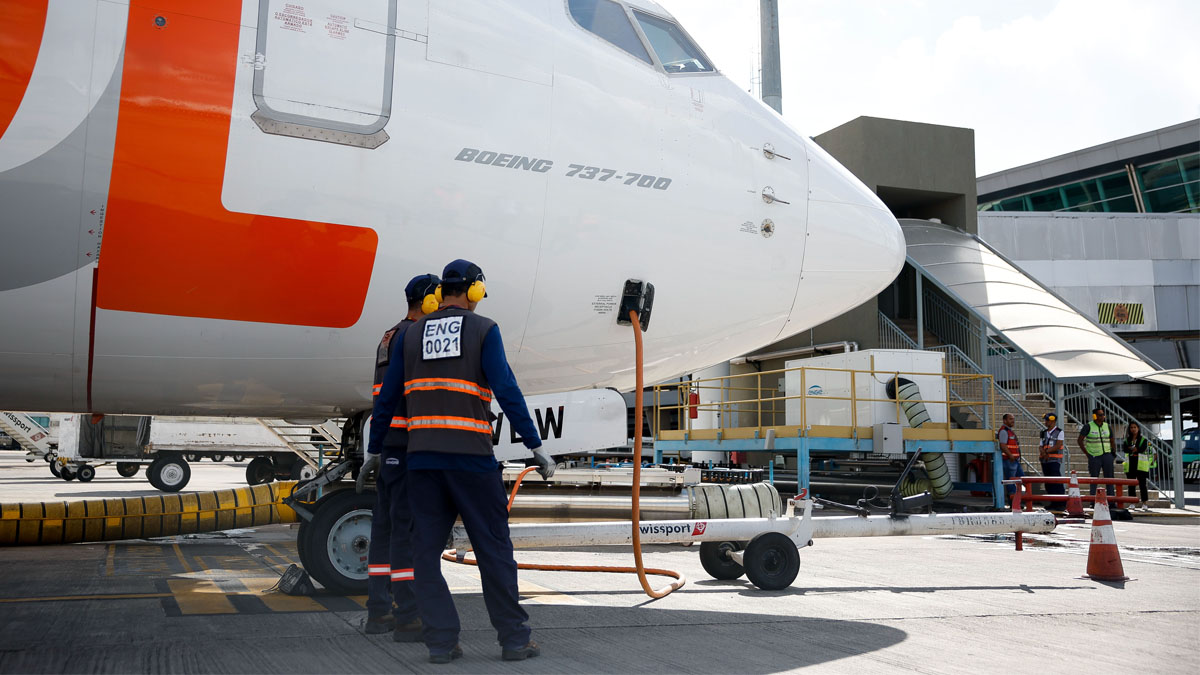 Dois homens abastecem um avião em um aeroporto