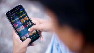 Garoto mexendo no celular com site de bet aberto