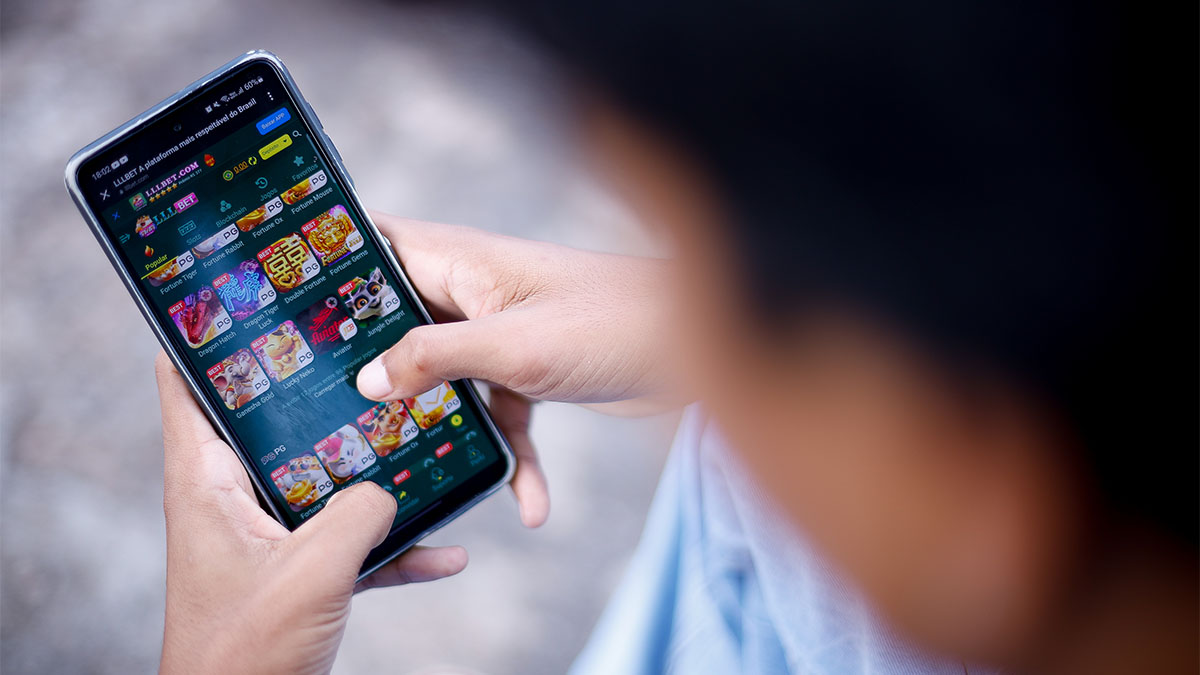 Garoto mexendo no celular com site de bet aberto