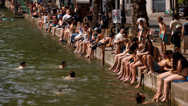 Franceses aglomerados em rio por conta do calor. Local é o canal de Saint Martin