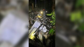 Bombeiro atua entre os escombros de uma casa que desabou na zona leste de São Paulo durante a noite