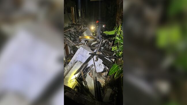 Bombeiro atua entre os escombros de uma casa que desabou na zona leste de São Paulo durante a noite