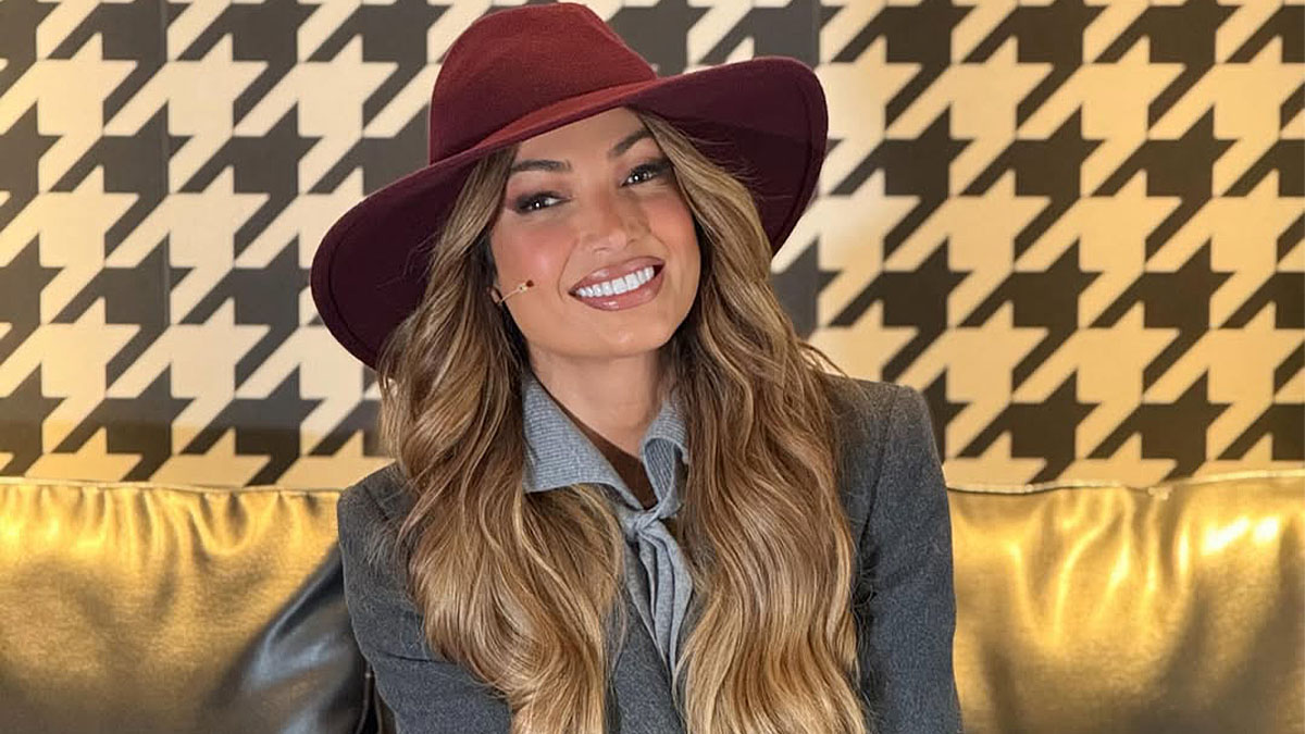 Mulher centralizada com roupas de inverno e sorrindo.