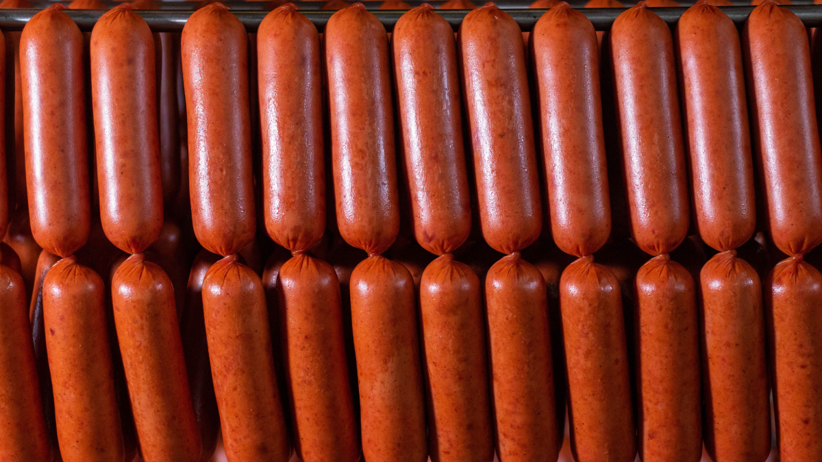A produção da salsicha passa por etapas como moagem, mistura, cozimento e embalagem (Foto: Pexels)