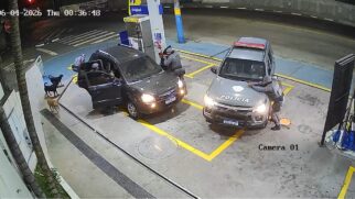 Policiais armados cercam um carro em um posto de combustíveis durante uma abordagem realizada à noite