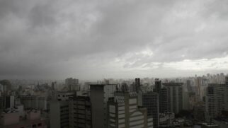 Vista panorâmica da cidade de São Paulo sob céu carregado e chuva em áreas da capital
