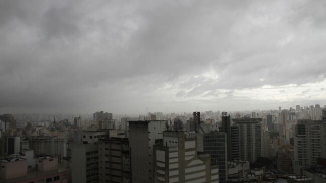 Vista panorâmica da cidade de São Paulo sob céu carregado e chuva em áreas da capital