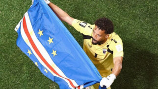 Goleiro Vozinha após empate de Cabo Verde. Ele segura a bandeira do país.
