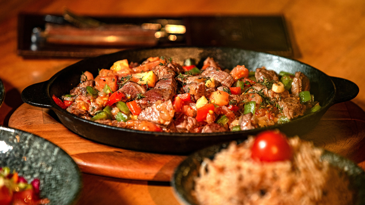 Carne assada dourada ao lado de cenouras e cebolas caramelizadas é uma opção clássica para reunir a família (Foto: Mohamed Olwy/ Pexels)