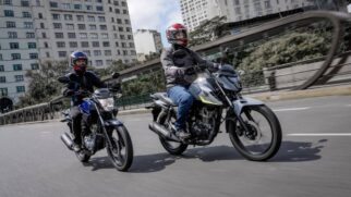 Duas motos Honda CGs trafegando pela rua