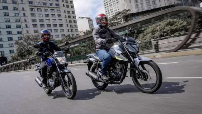 Duas motos Honda CGs trafegando pela rua