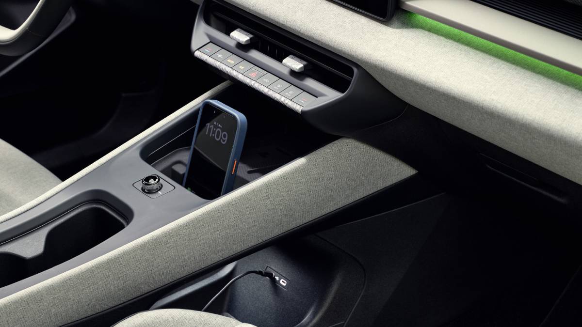 Detalhe do painel do Volkswagen ID. Cross verde com foco em um celular carregando