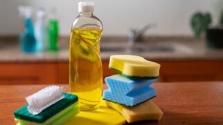 Mistura de vinagre branco com detergente sendo preparada em um balde para limpeza do piso da cozinha.