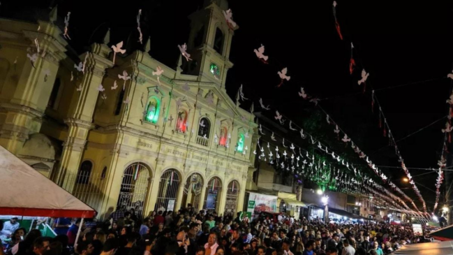 Igreja iluminada e ruas cheias resumem o encontro entre devoção, gastronomia e vida comunitária que marca a festa no Bixiga. (Foto: Wikimedia Commons)