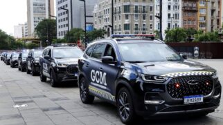 Fileira de viaturas SUV pretas da Guarda Civil Metropolitana (GCM) alinhadas em uma praça de piso quadriculado cinza