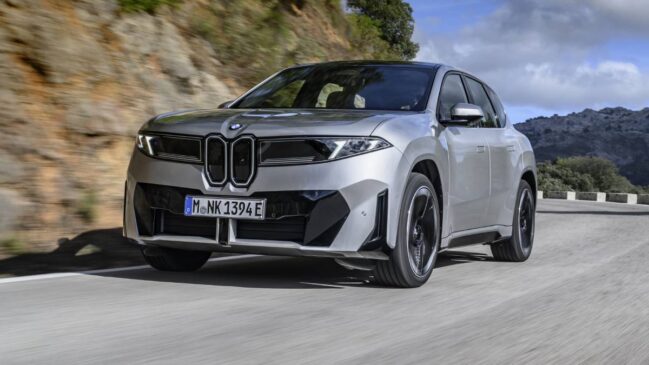 BMW iX3 prata trafegando no asfalto