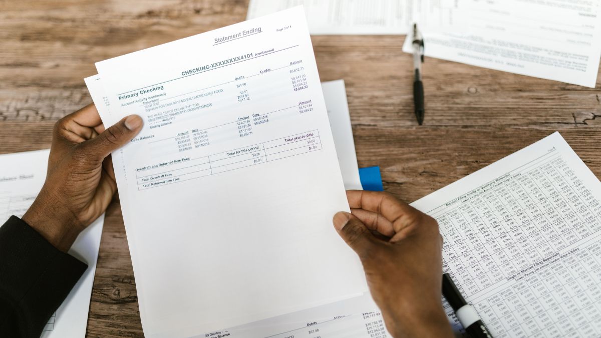Pessoa analisa contas e orçamento doméstico diante dos riscos financeiros associados às apostas online.