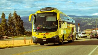 Ônibus de viagem amarelo em tráfego