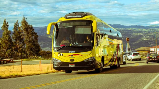 Ônibus de viagem amarelo em tráfego