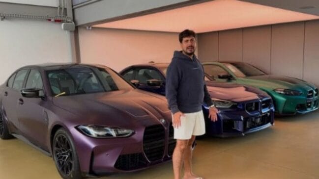 Eduardo Razuk em frente a três carros de luxo em garagem de casa