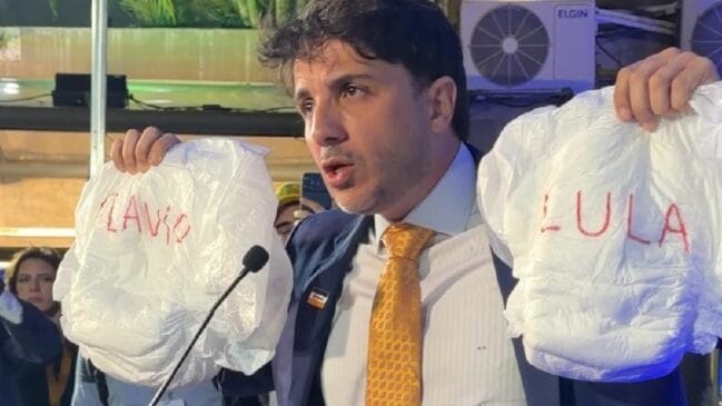 Renan Santos segura fraldas com nomes de Lula e Flávio