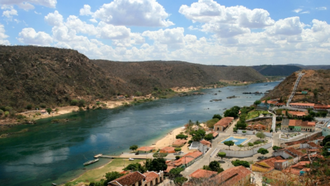 Piranhas aparece em meio ao relevo da região, com o casario histórico cercado pela paisagem do Rio São Francisco (Foto: Maria Hsu/Wikimedia Commons)
