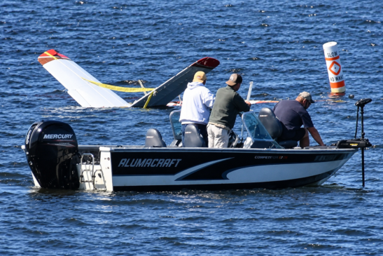 Barco participa da recuperação de avião parcialmente submerso após pouso de emergência em um lago de Wisconsin.
