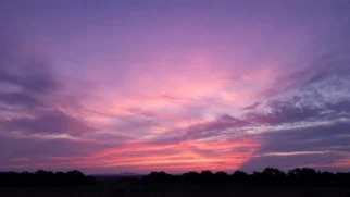 Céu após o pôr do sol com nuvens altas tingidas de rosa e violeta