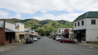Rua comercial calma de cidade do interior com colinas verdes ao fundo na Nova Zelândia